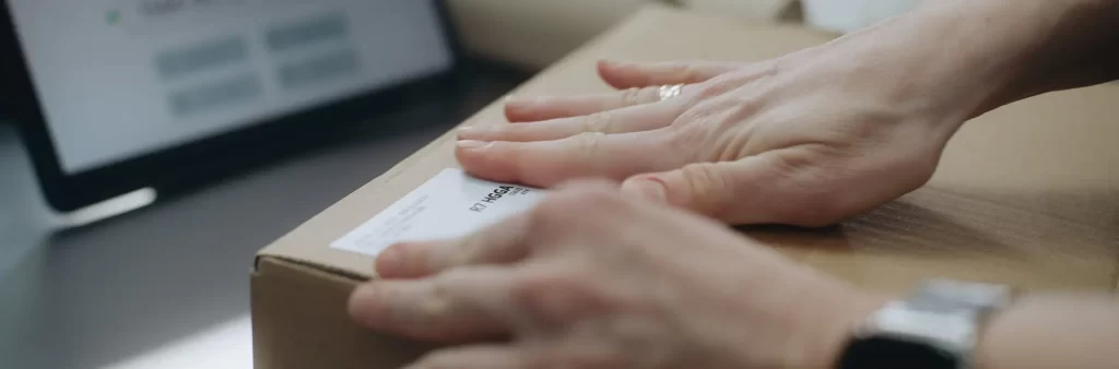 header woman sticks label on package